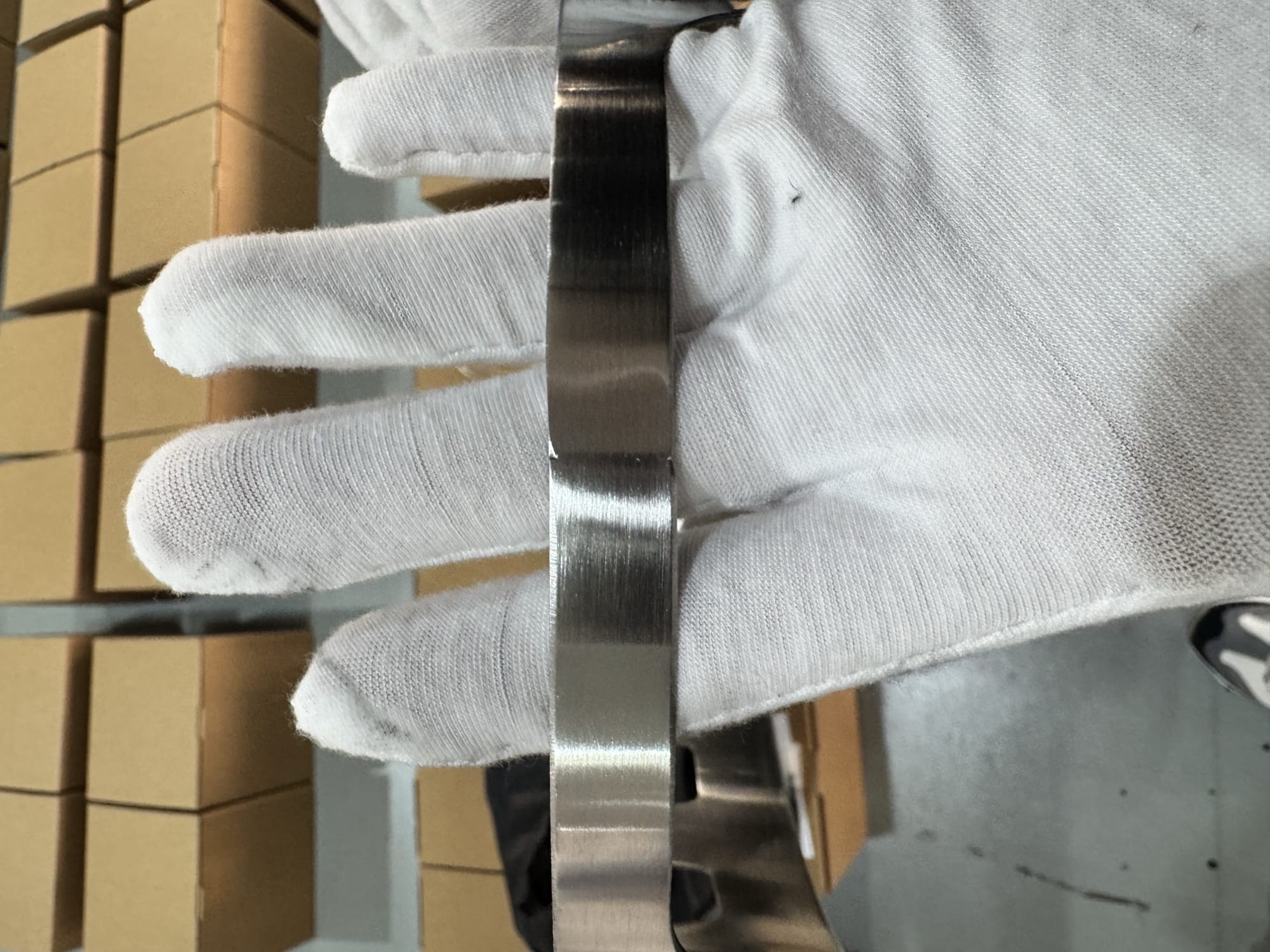 AQL 2.5 fire pit QC inspection — close-up of a stainless steel rim seam being checked by a gloved inspector
